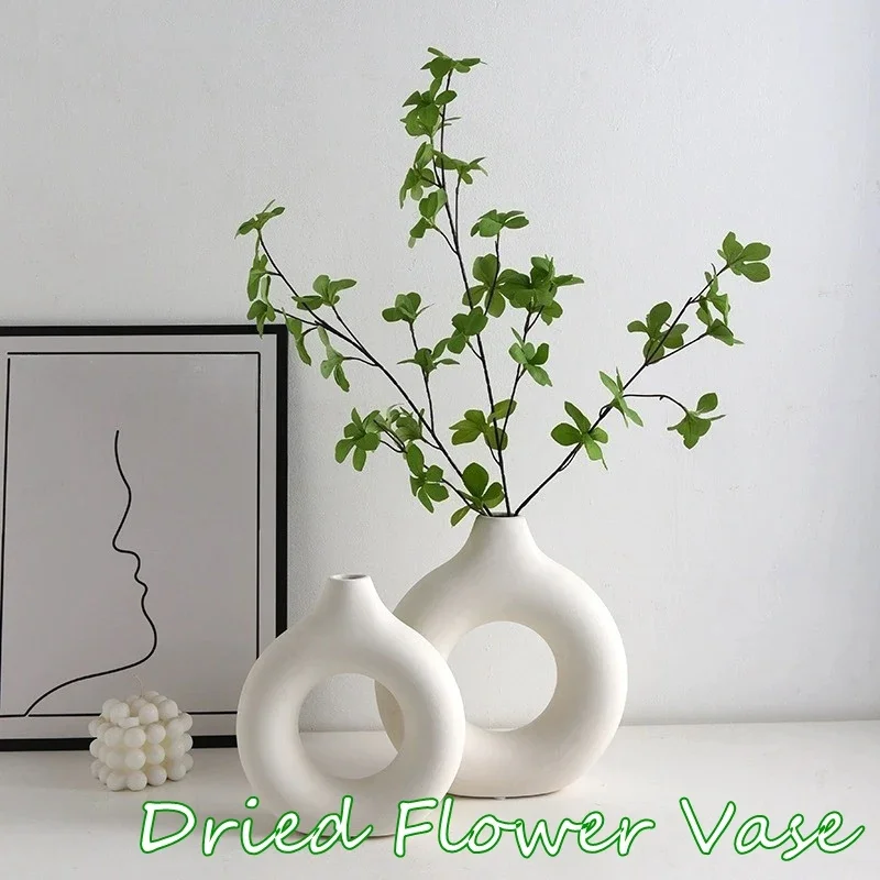 Vase blanc minimaliste élégant avec une fleur séchée unique sur une table