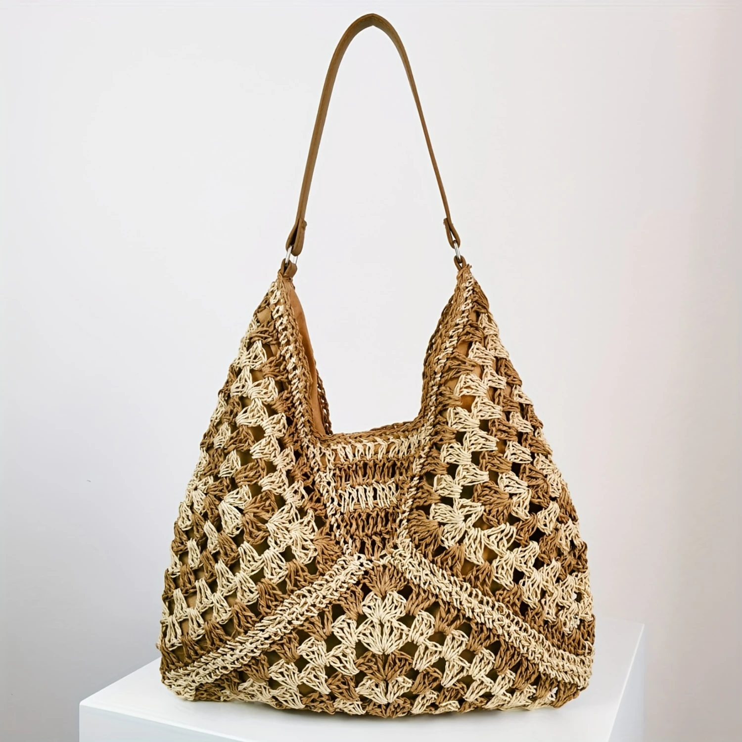 Modèle portant le sac Hobo en paille sur une plage