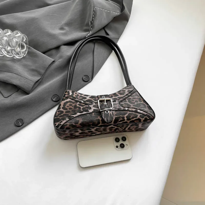 Femme portant le sac sous le bras, montrant sa taille parfaite