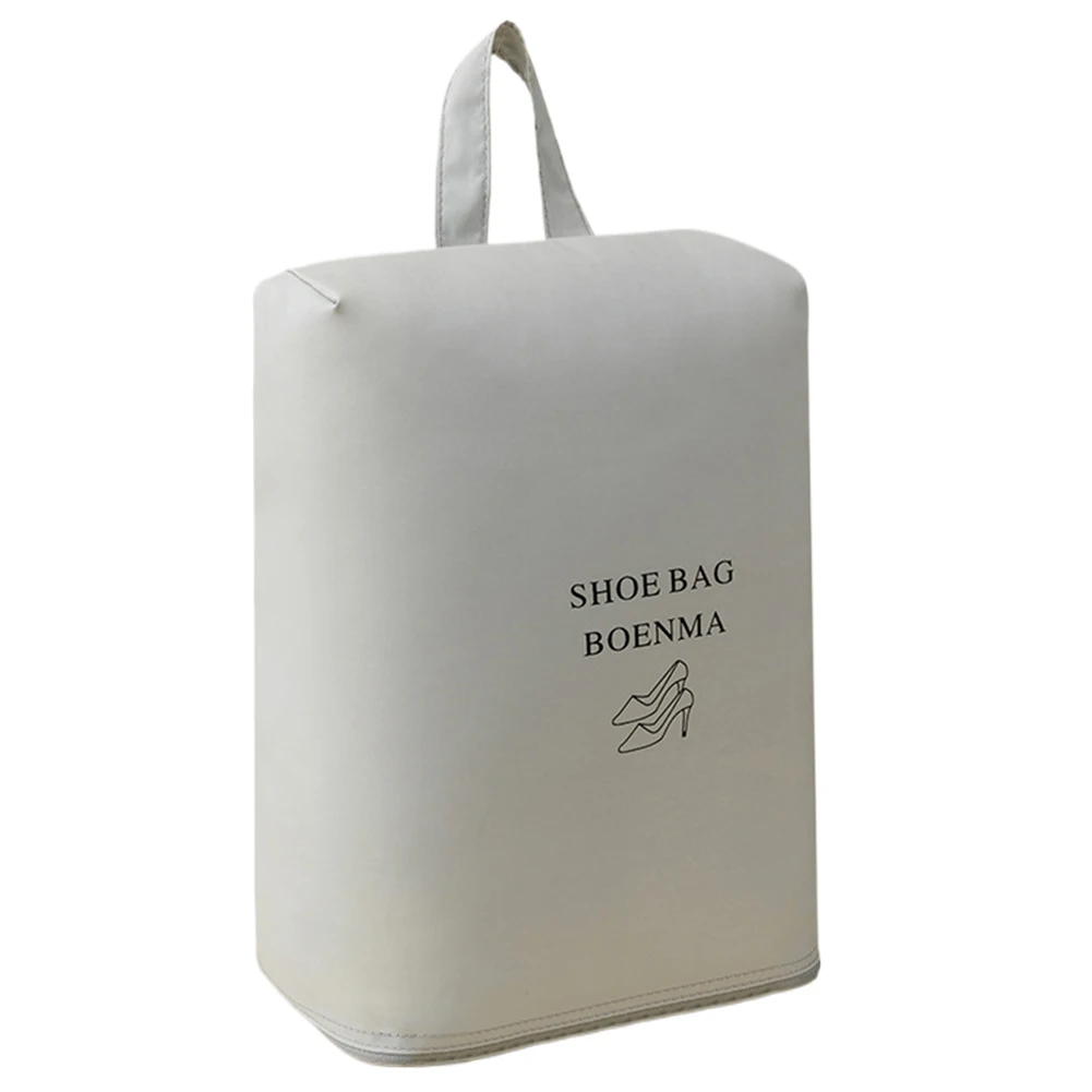 Sac de Voyage à Chaussures Portable - Anti-Poussière & Imperméable Un sac à chaussures gris clair tenu par la poignée, avec des détails du tissu texturé