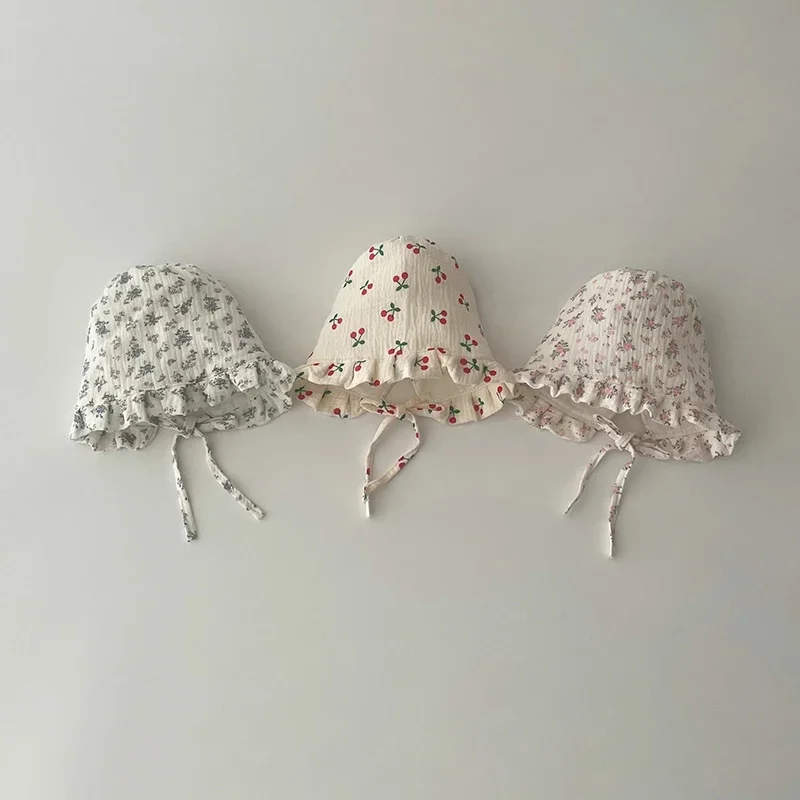 Chapeau de soleil bébé rose avec motif floral en coton sur fond uni