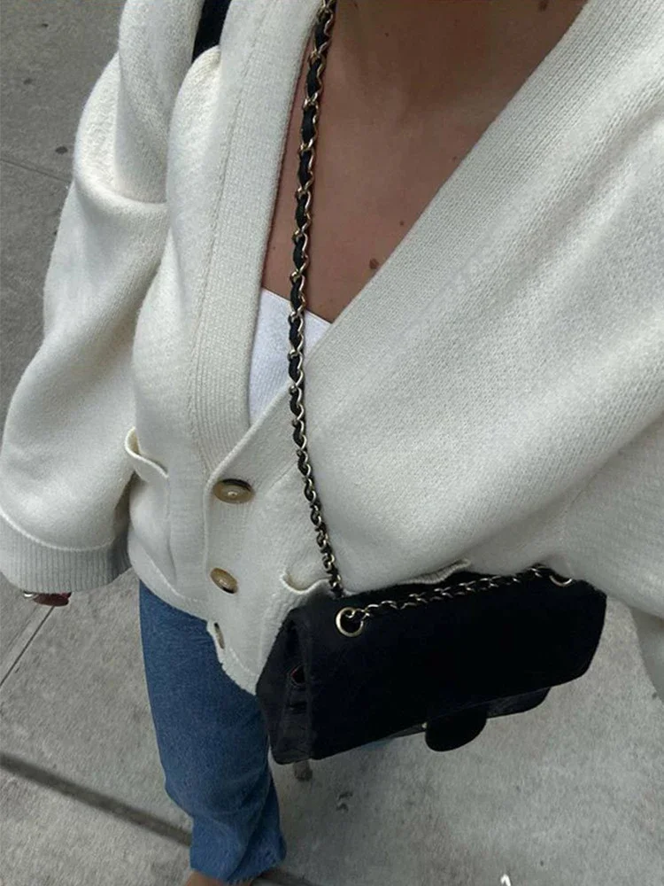 Femme posant avec un cardigan court et un jean taille haute