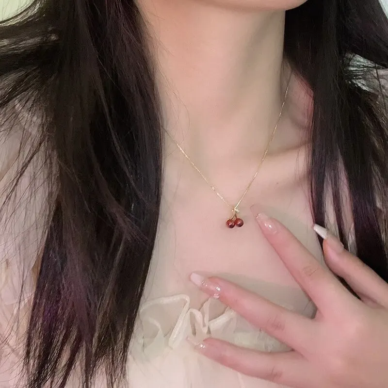 Collier cerise porté par une femme, vue rapprochée du cou, élégance