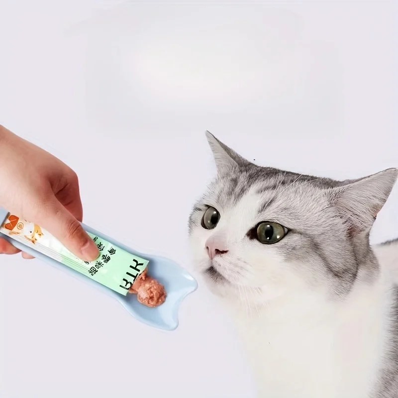 Chat léchant la cuillère distributrice